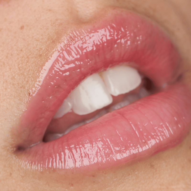 Translation missing: nl.Close-up van glanzende, roze lippen gehuld in Lip Jelly Rose. De lippen hebben een subtiele, natuurlijke kleur en een gezonde, gehydrateerde uitstraling