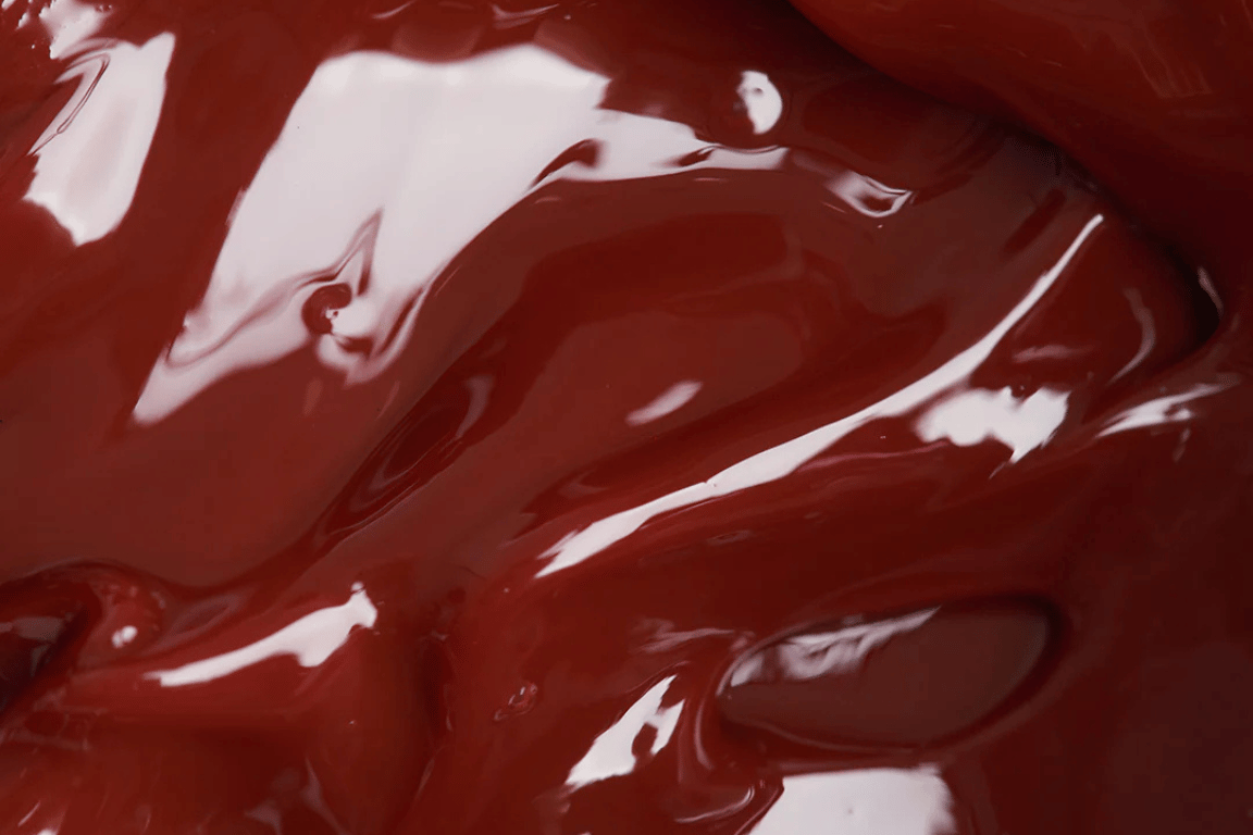 Glanzende, dieprode geltextuur van Lip Jelly Berry; close-up in de ingrediënten-sectie.