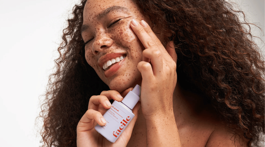 Model met sproeten schuimt Facile Bare Necessity Cleanser op de huid – laat zien hoe barrier‑friendly, vegan easy‑cosmetics een simple routine maken.